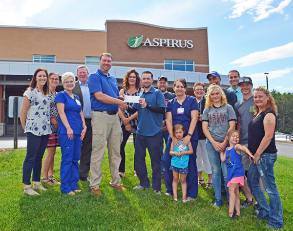 Jeff Graumann presents the charitable Graumann FIGHT THE CANCER Ride check to Aspirus Medford Foundation Chair Randy Juedes.